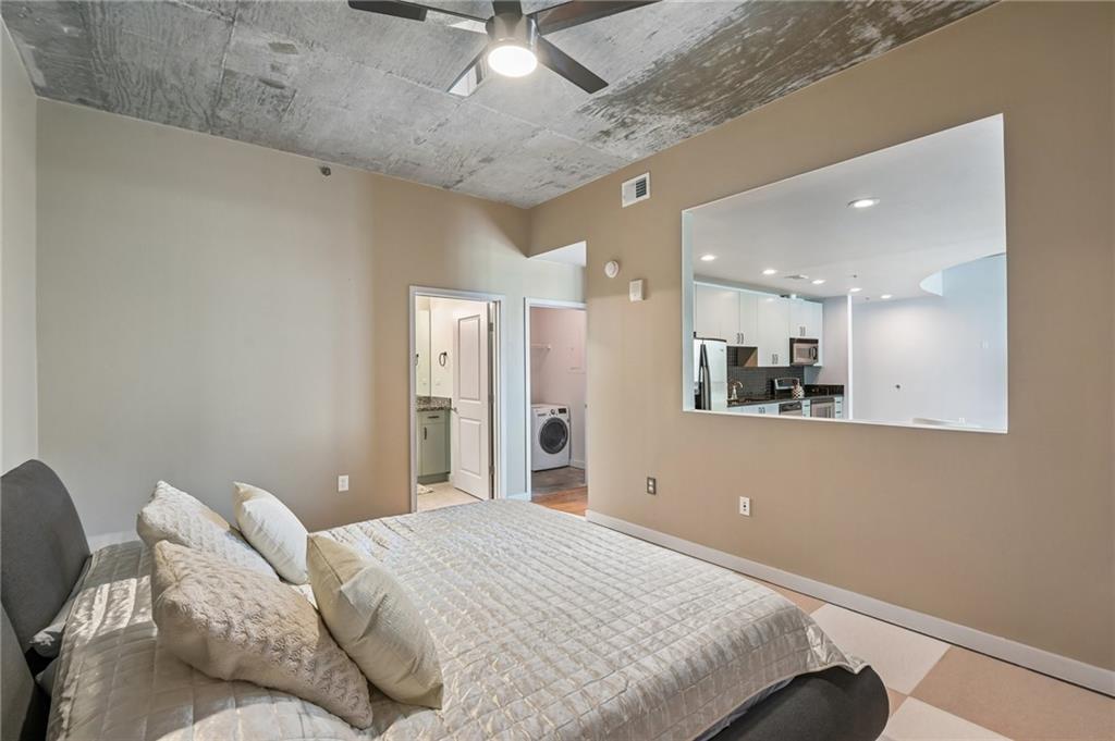 250 Pharr Road Northeast, Unit 701 Atlanta, GA 30305 - Photo 10 of 21 a bedroom with a bed and a mirror