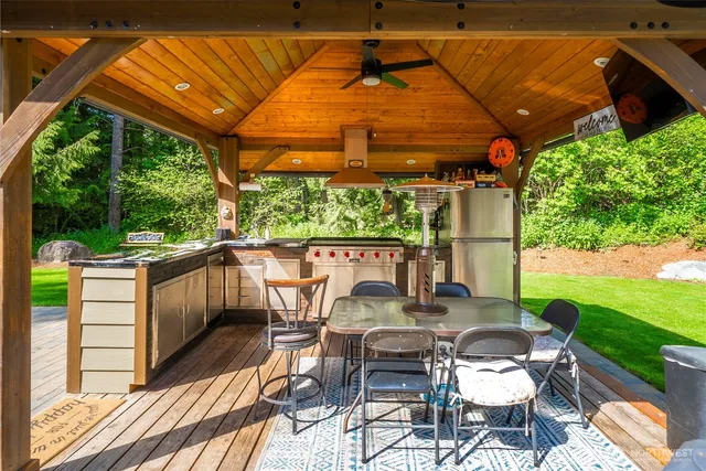 a view of a wooden house with a yard and sitting area