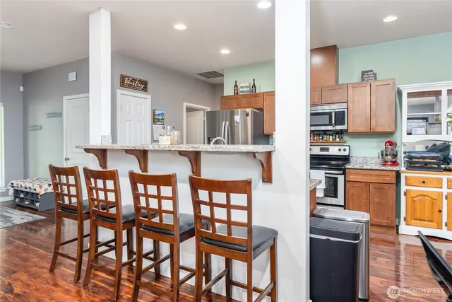 a dining room with wooden floor a chandelier a wooden table and chairs