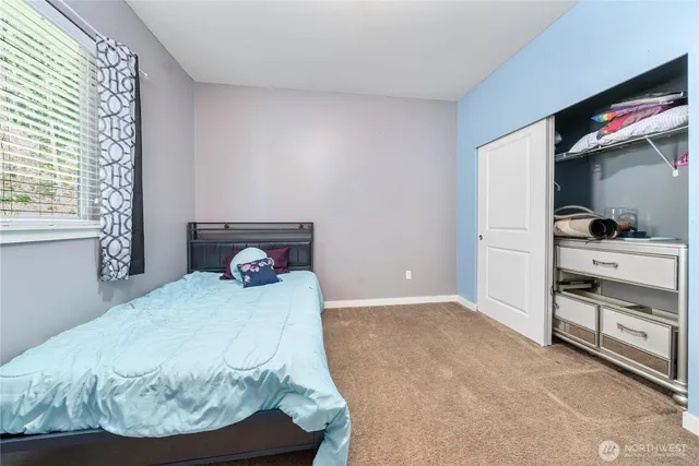 a bedroom with a bed a dresser and a window