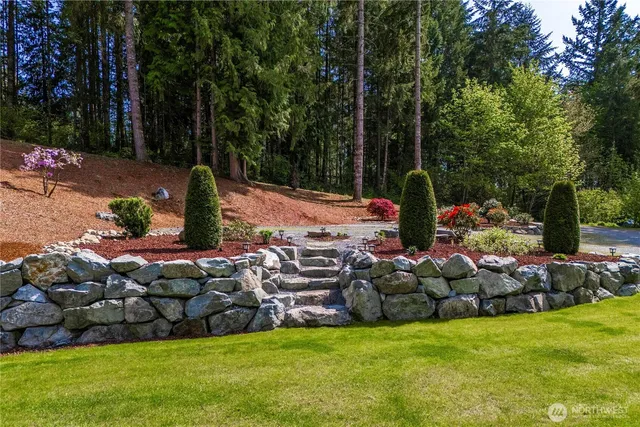 a view of a patio with table and chairs potted plants and large tree