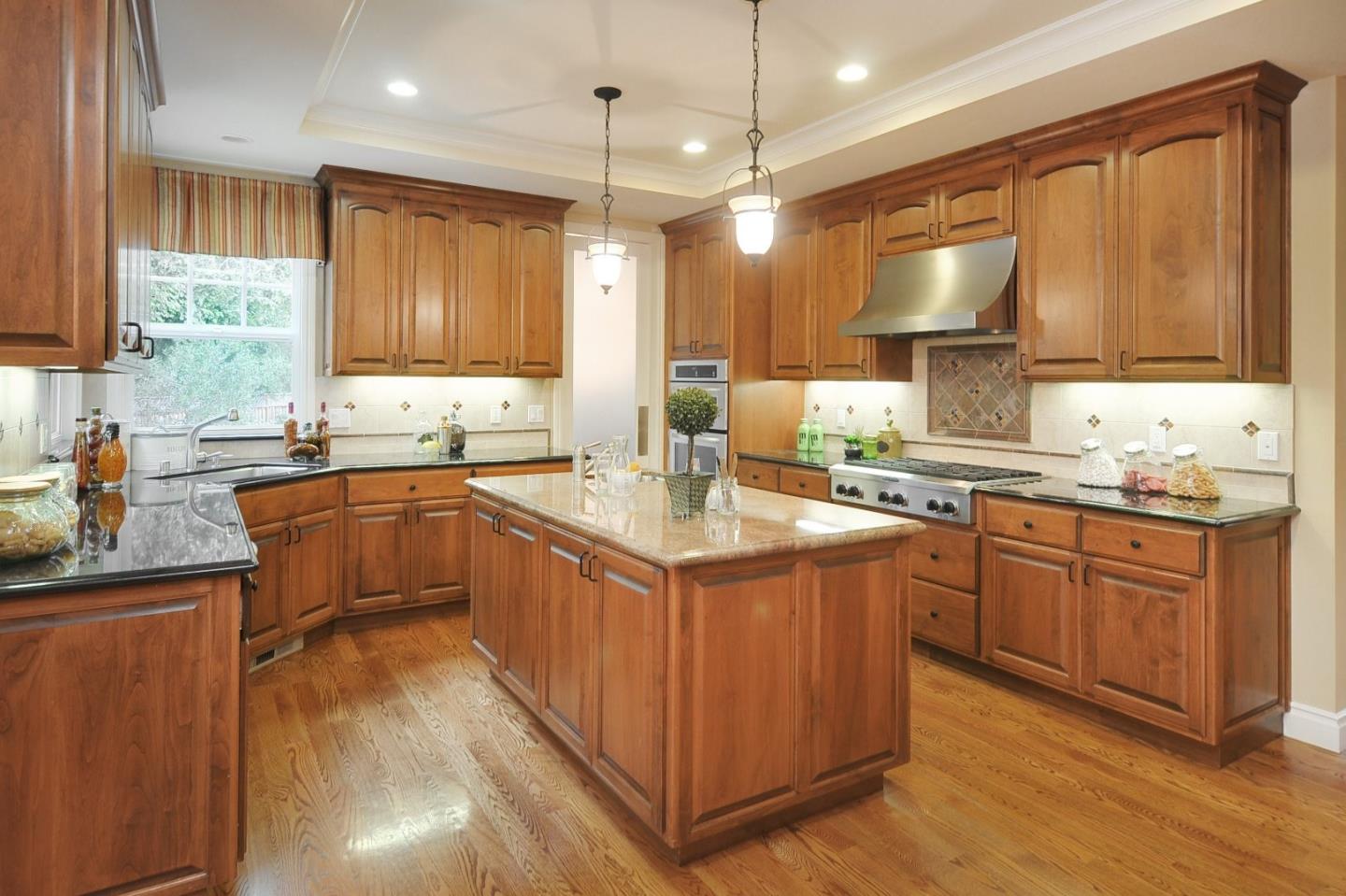 738 Springer Road Los Altos, CA 94024 - Photo 5 of 25 a kitchen with kitchen island granite countertop a sink stove and wooden cabinets