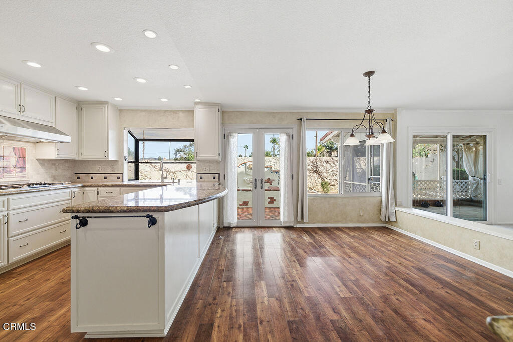 4024 Cliffrose Avenue Moorpark, CA 93021 - Photo 12 of 40 a large kitchen with stainless steel appliances kitchen island a large counter top and a wooden floors