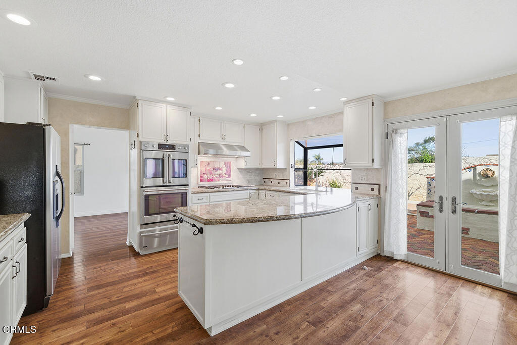4024 Cliffrose Avenue Moorpark, CA 93021 - Photo 13 of 40 a kitchen with stainless steel appliances granite countertop a refrigerator and a stove top oven
