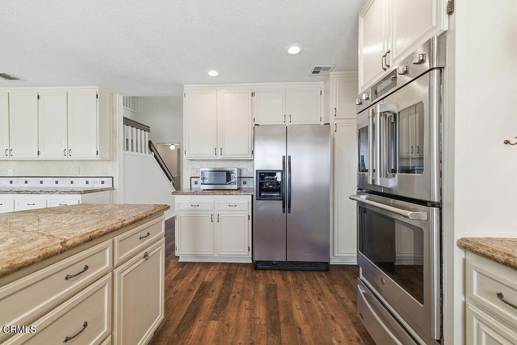 4024 Cliffrose Avenue Moorpark, CA 93021 - Photo 14 of 40 a kitchen with kitchen island granite countertop a refrigerator oven a sink and dishwasher