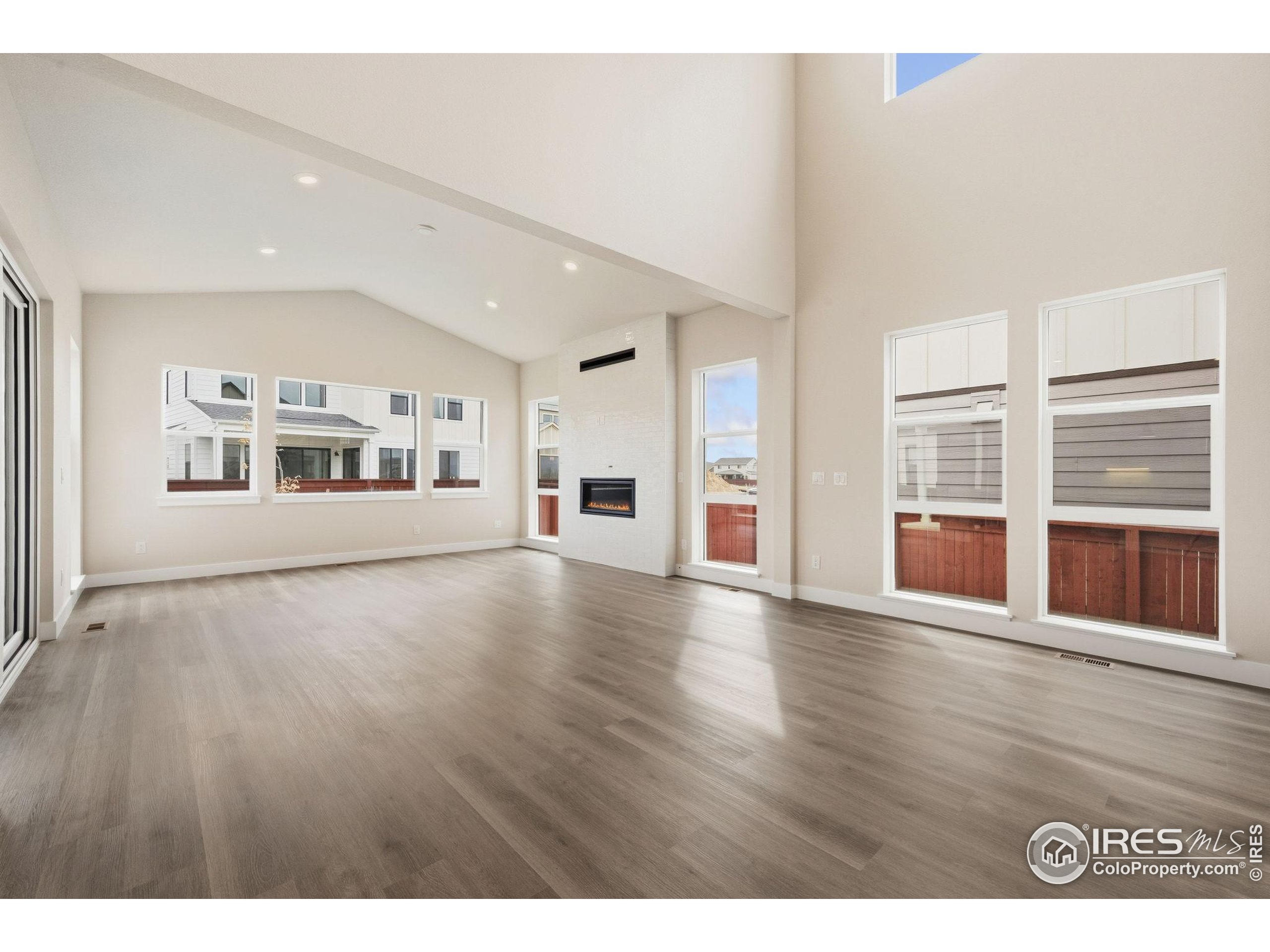 1675 Sundown Run Drive Windsor, CO 80550 - Photo 3 of 15 a view of an empty room with a window and wooden floor