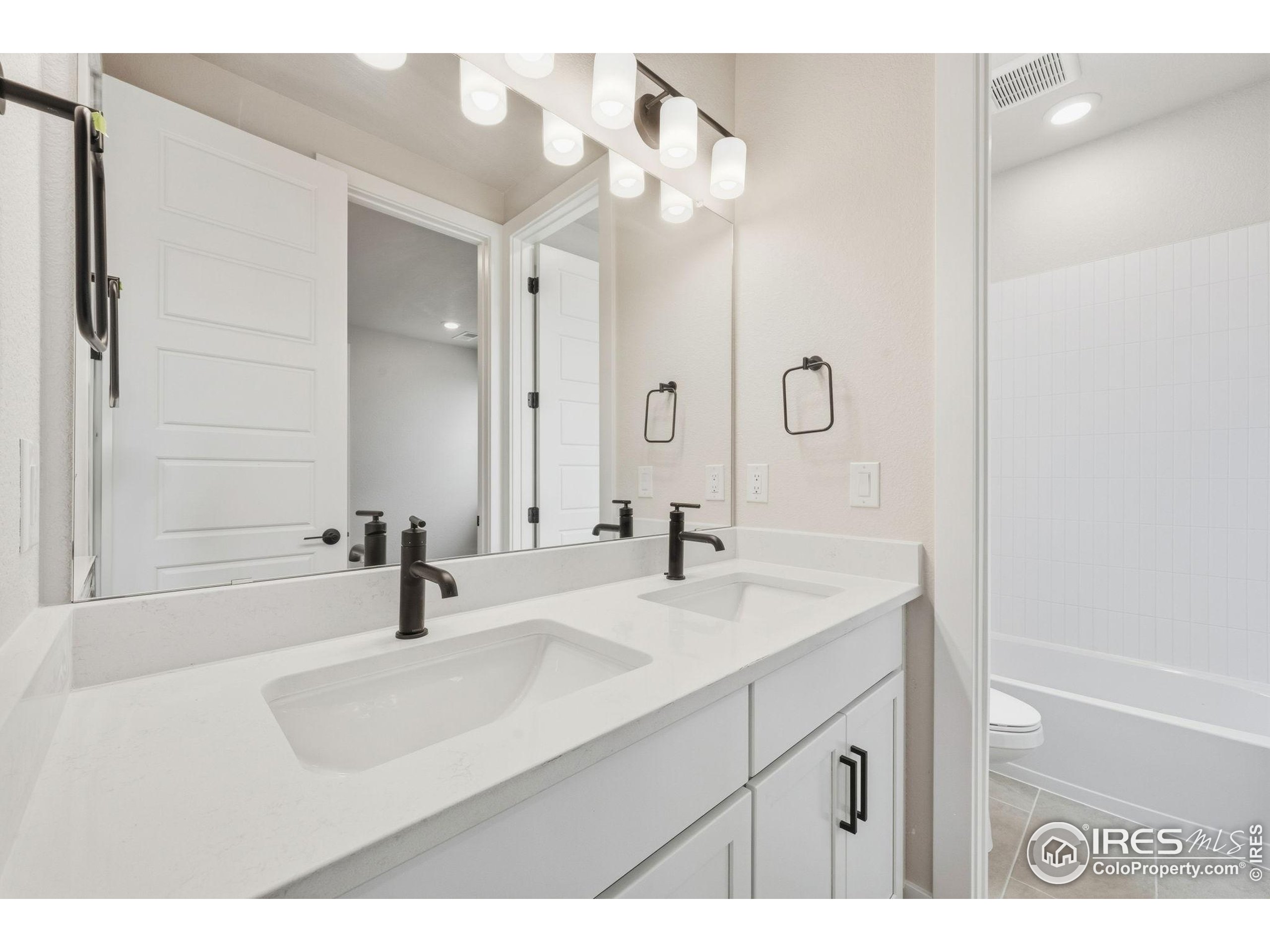 1675 Sundown Run Drive Windsor, CO 80550 - Photo 10 of 15 a bathroom with a sink and a mirror with bathtub