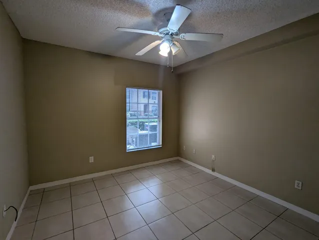an empty room with windows and fan