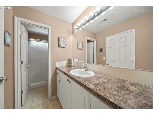 a bathroom with a granite countertop double vanity sink and mirror