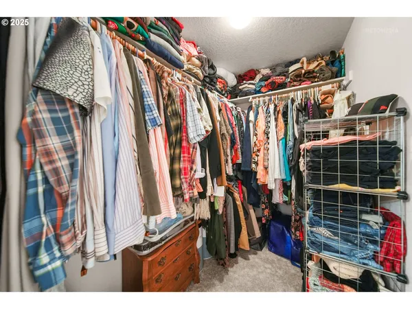 a view of walk in closet with clothes