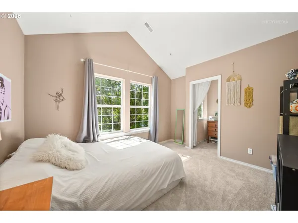 a bedroom with a bed and a large window