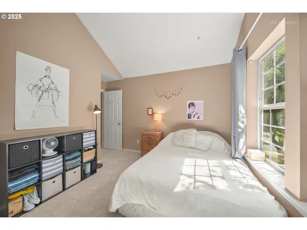 a bedroom with a bed and a large window