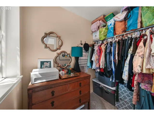 a view of walk in closet with clothes and shoes