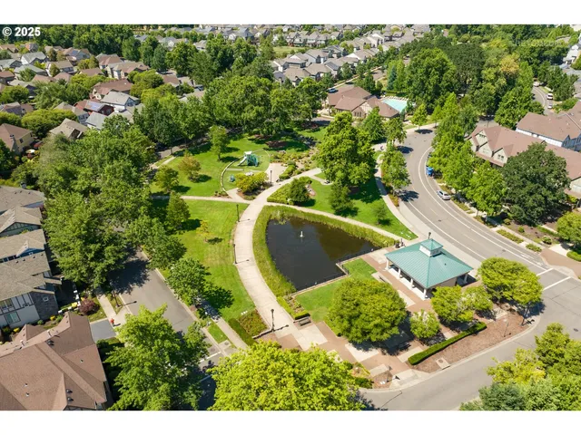 an aerial view of residential house with outdoor space and trees all around