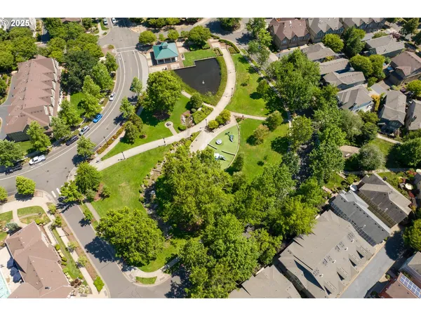 an aerial view of residential house with outdoor space and trees all around