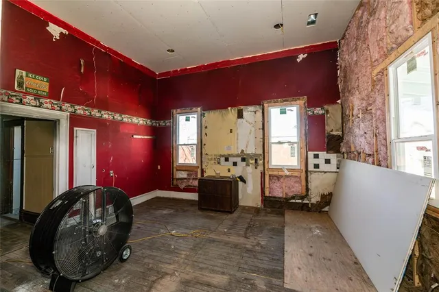 a living room with furniture a flat screen tv and large windows