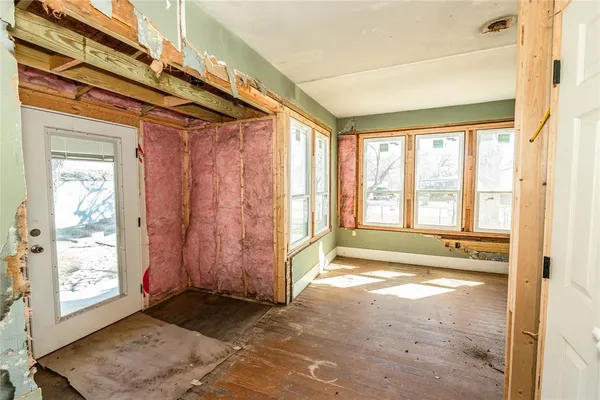 a view of a livingroom with a fireplace wooden floor and window