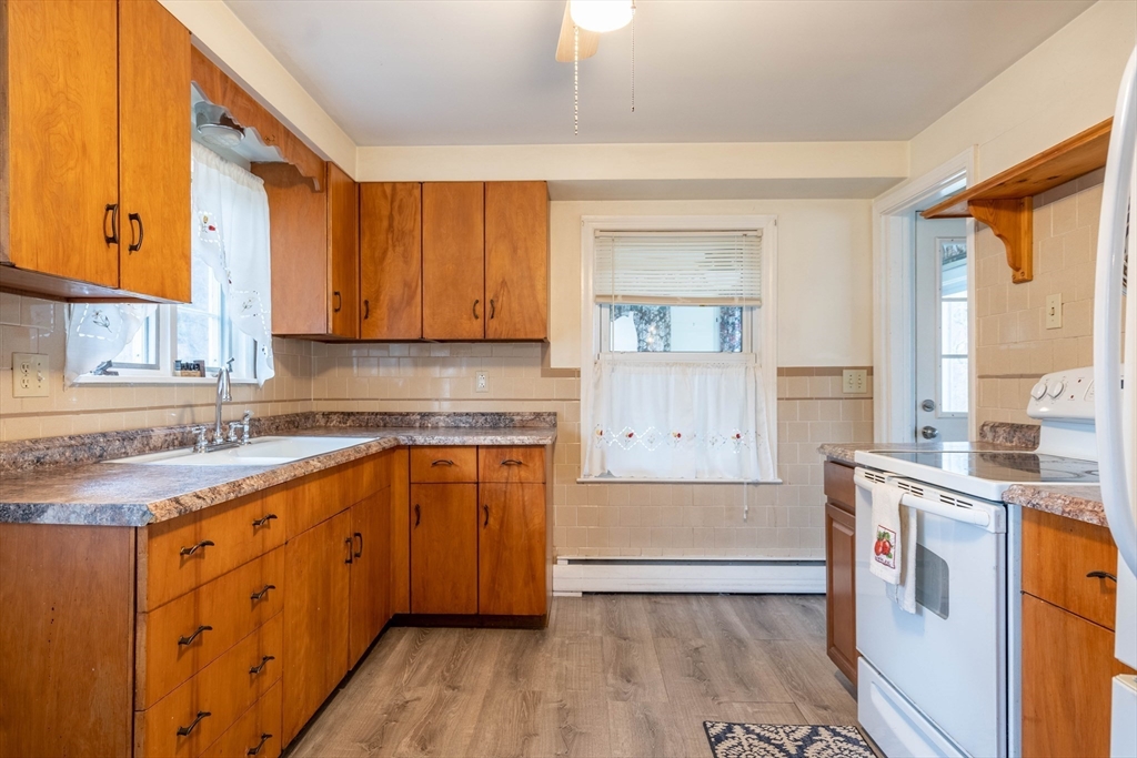 838 Pleasant Street Rochdale, MA 01542 - Photo 13 of 30 a kitchen with stainless steel appliances granite countertop a sink a stove cabinets and wooden floor
