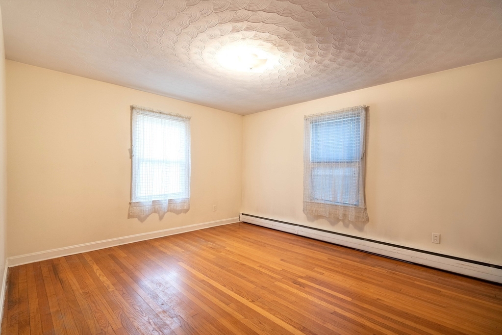 838 Pleasant Street Rochdale, MA 01542 - Photo 17 of 30 an empty room with wooden floor and windows