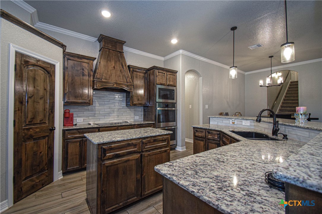 7623 Palladium Loop Killeen, TX 76542 - Photo 12 of 48 a kitchen with stainless steel appliances granite countertop wooden cabinets a sink and a stove