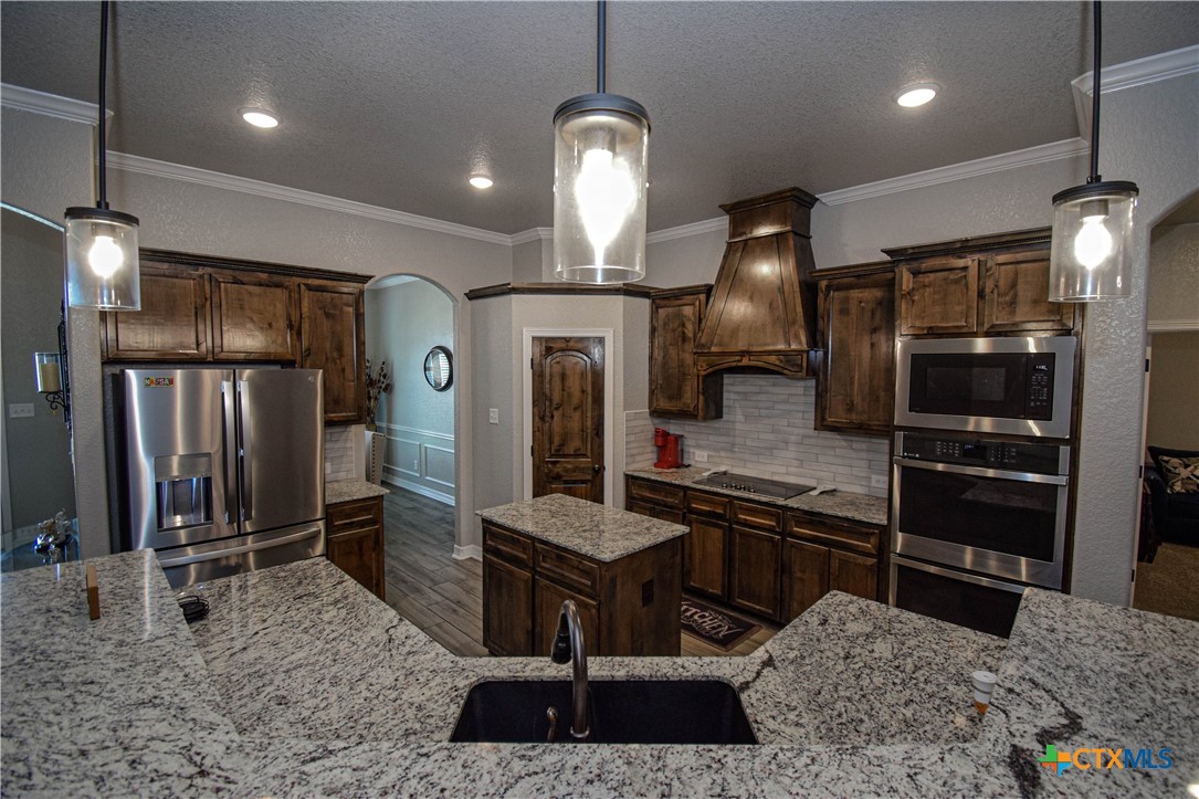 7623 Palladium Loop Killeen, TX 76542 - Photo 14 of 48 a kitchen with stainless steel appliances granite countertop a sink a stove and a refrigerator
