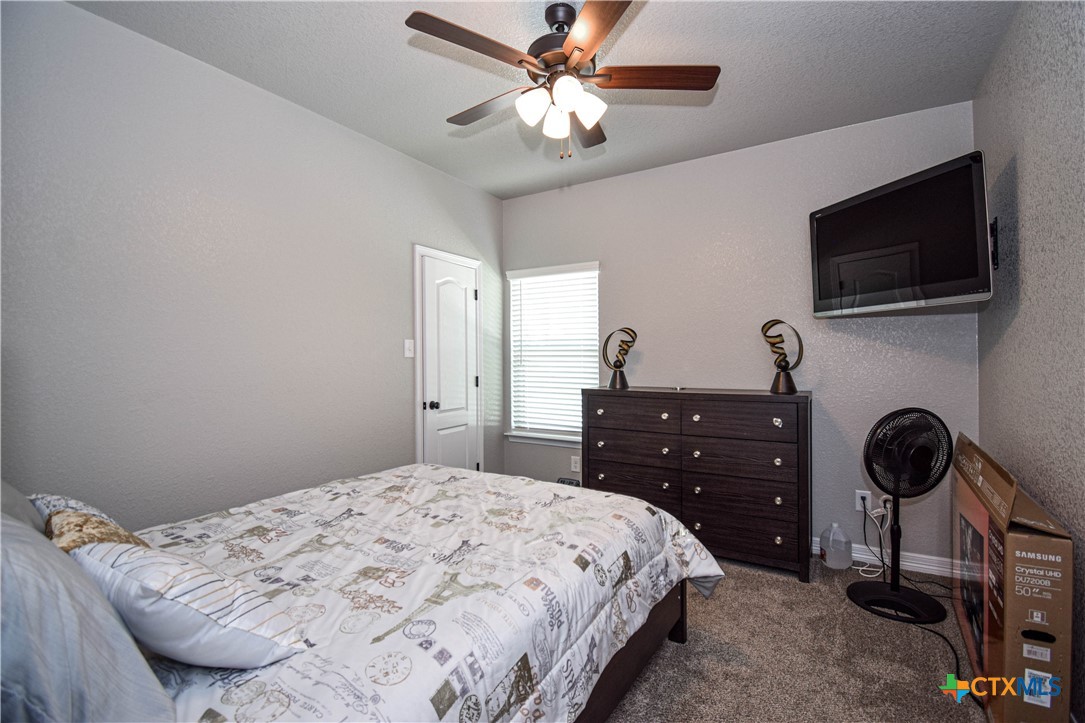 7623 Palladium Loop Killeen, TX 76542 - Photo 25 of 48 a bedroom with a bed and a flat tv screen on the dresser