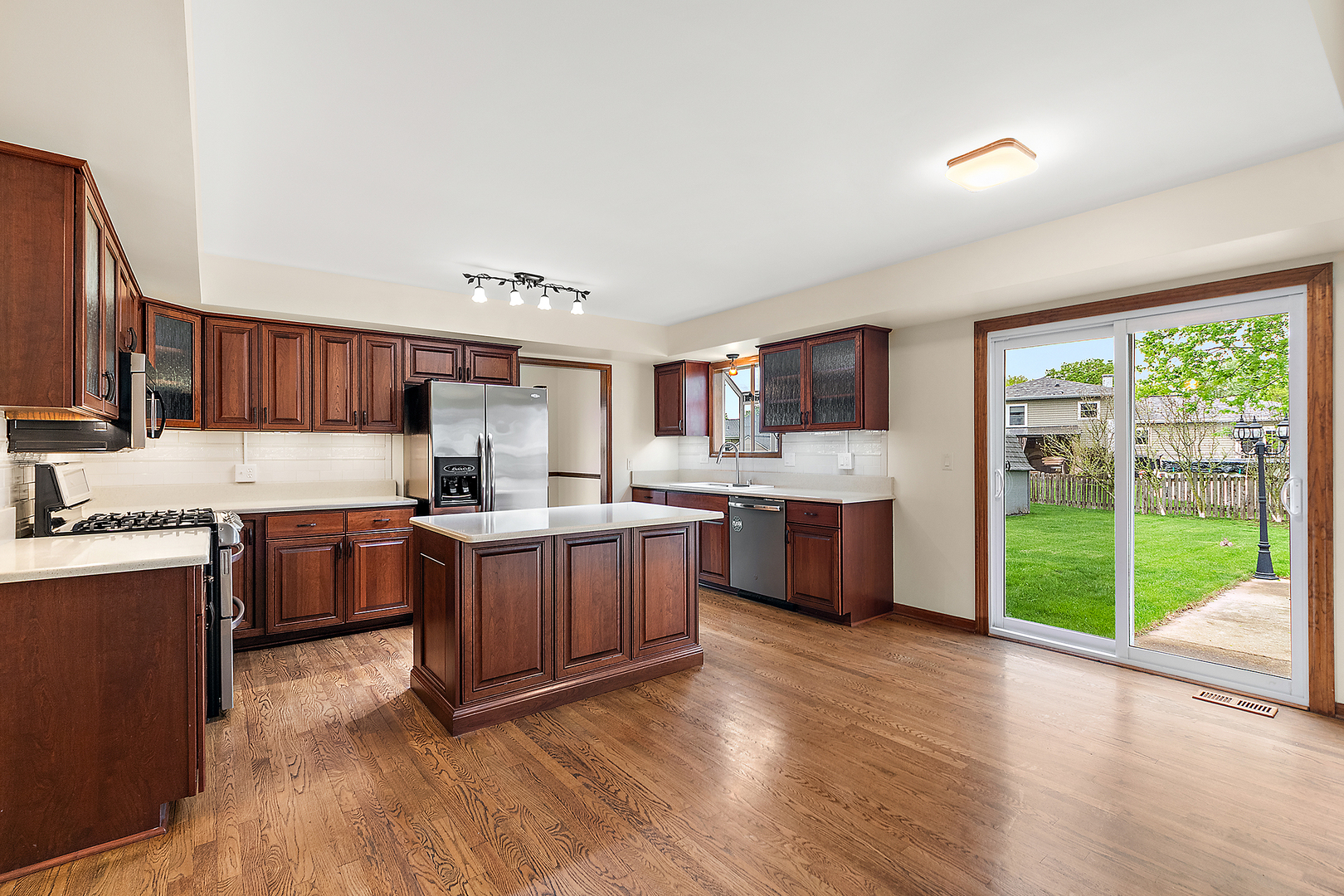 1408 Fawn Court Bolingbrook, IL 60490 - Photo 11 of 35 a kitchen with stainless steel appliances granite countertop a stove a sink dishwasher a refrigerator and a dining table with wooden floor