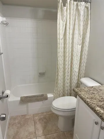 a bathroom with a granite countertop bathtub toilet and sink
