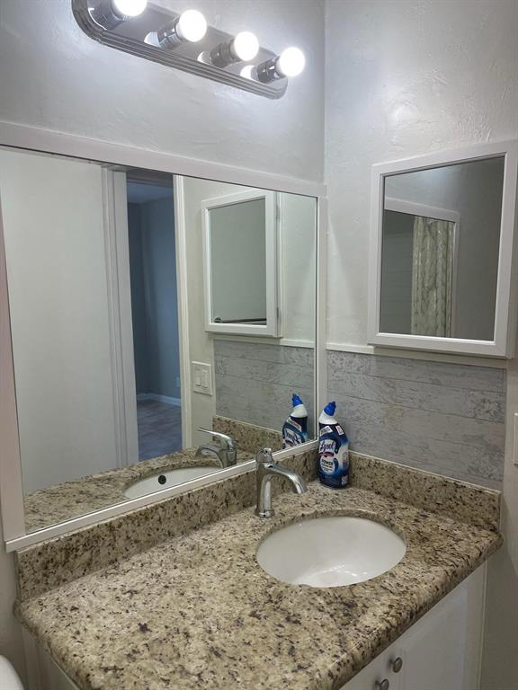 4521 Northeast 21st Avenue, Unit 2 Fort Lauderdale, FL 33308 - Photo 5 of 10 a bathroom with a granite countertop sink and a mirror