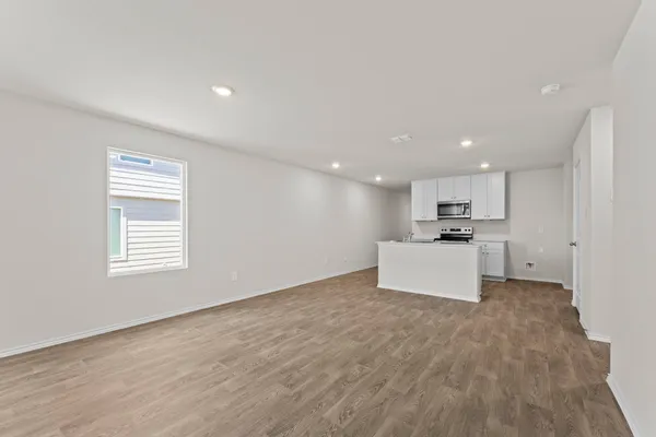 a view of kitchen appliances kitchen island wooden floor and window