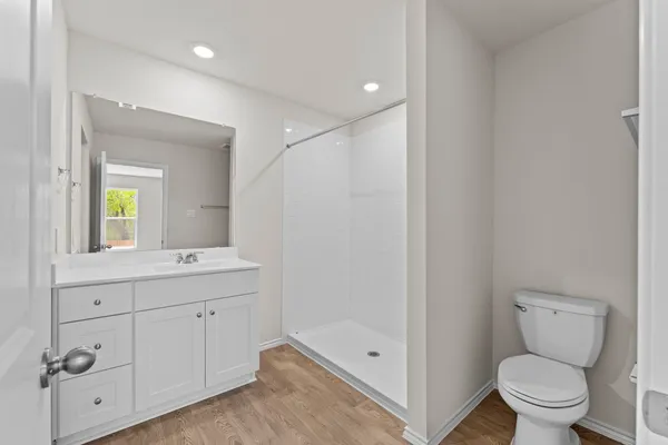 a bathroom with a sink a toilet and shower