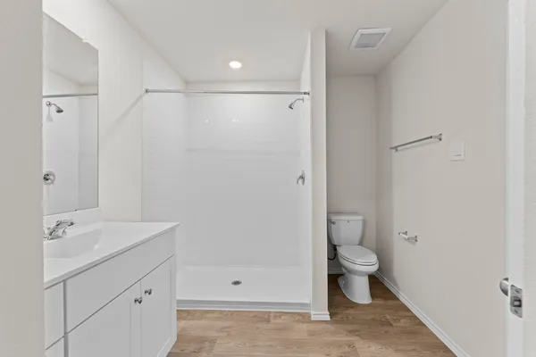 a bathroom with a shower sink vanity and toilet