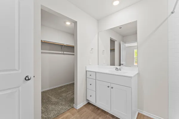 a bathroom with a granite countertop sink two mirror and a vanity