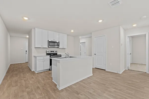 a kitchen with white cabinets and stainless steel appliances