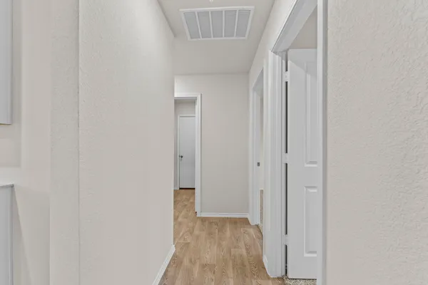 a view of a hallway with wooden floor and entryway