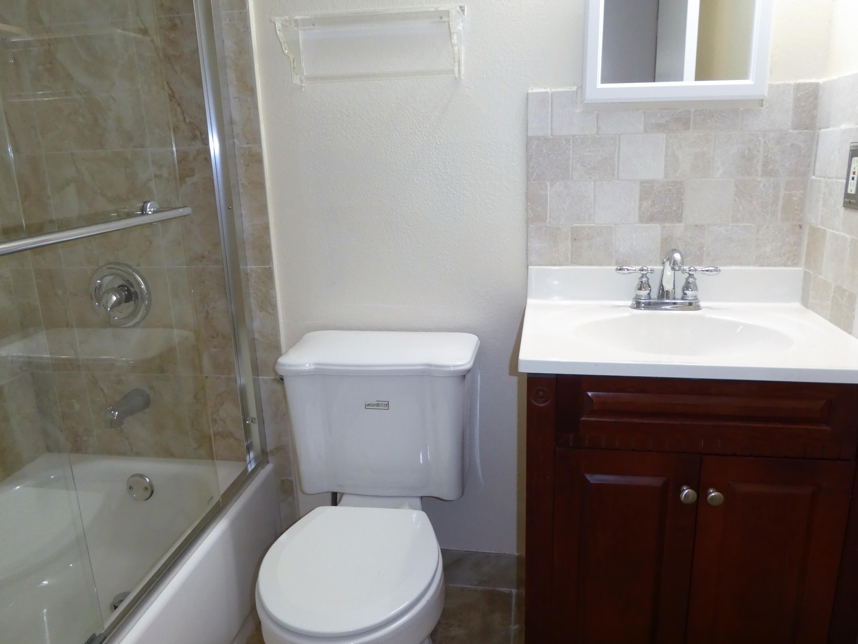 9855 Sandalfoot Boulevard, Unit 306 Boca Raton, FL 33428 - Photo 11 of 25 a bathroom with a sink a toilet and shower