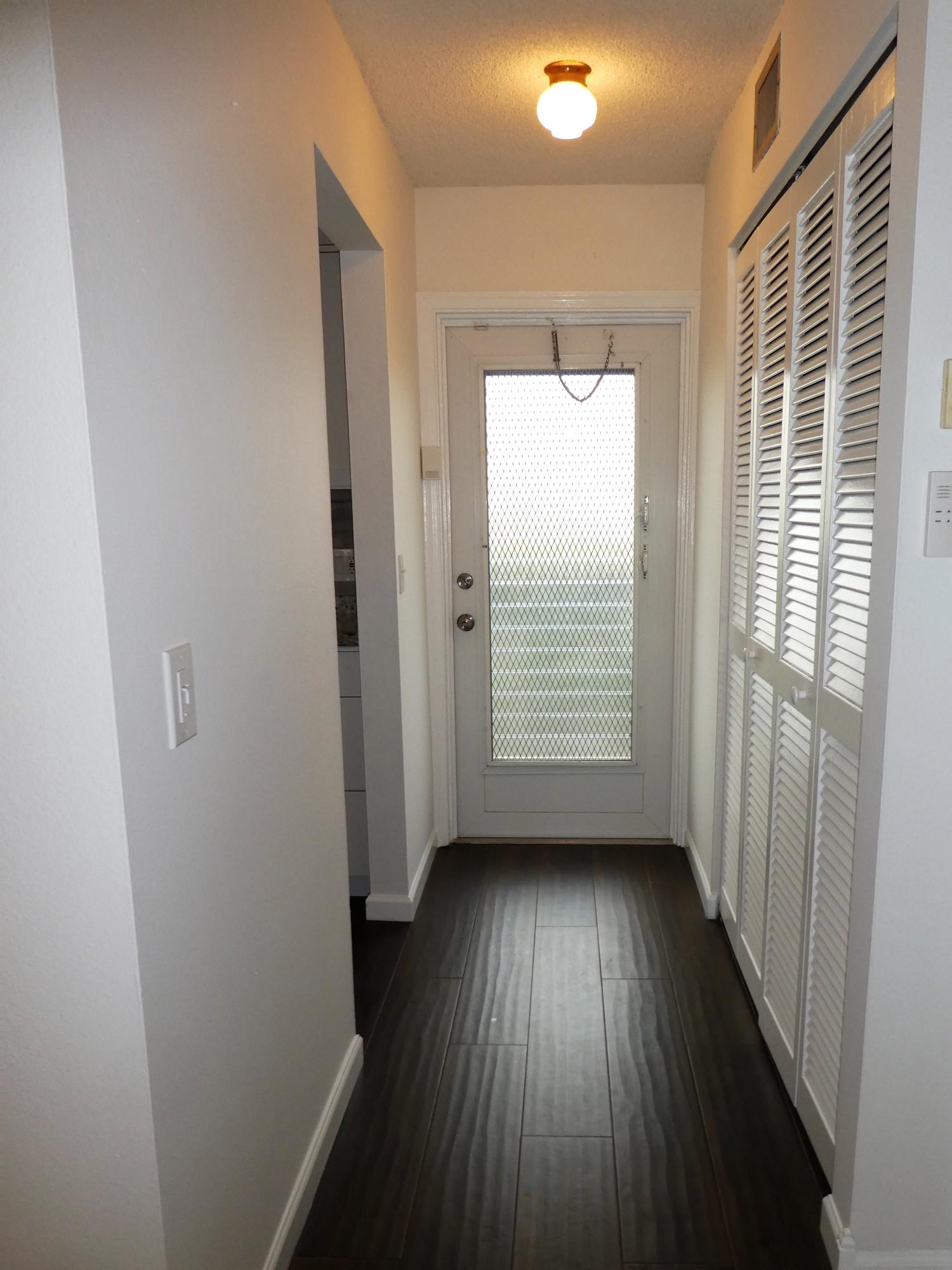 9855 Sandalfoot Boulevard, Unit 306 Boca Raton, FL 33428 - Photo 13 of 25 a view of an empty room with wooden floor and a window