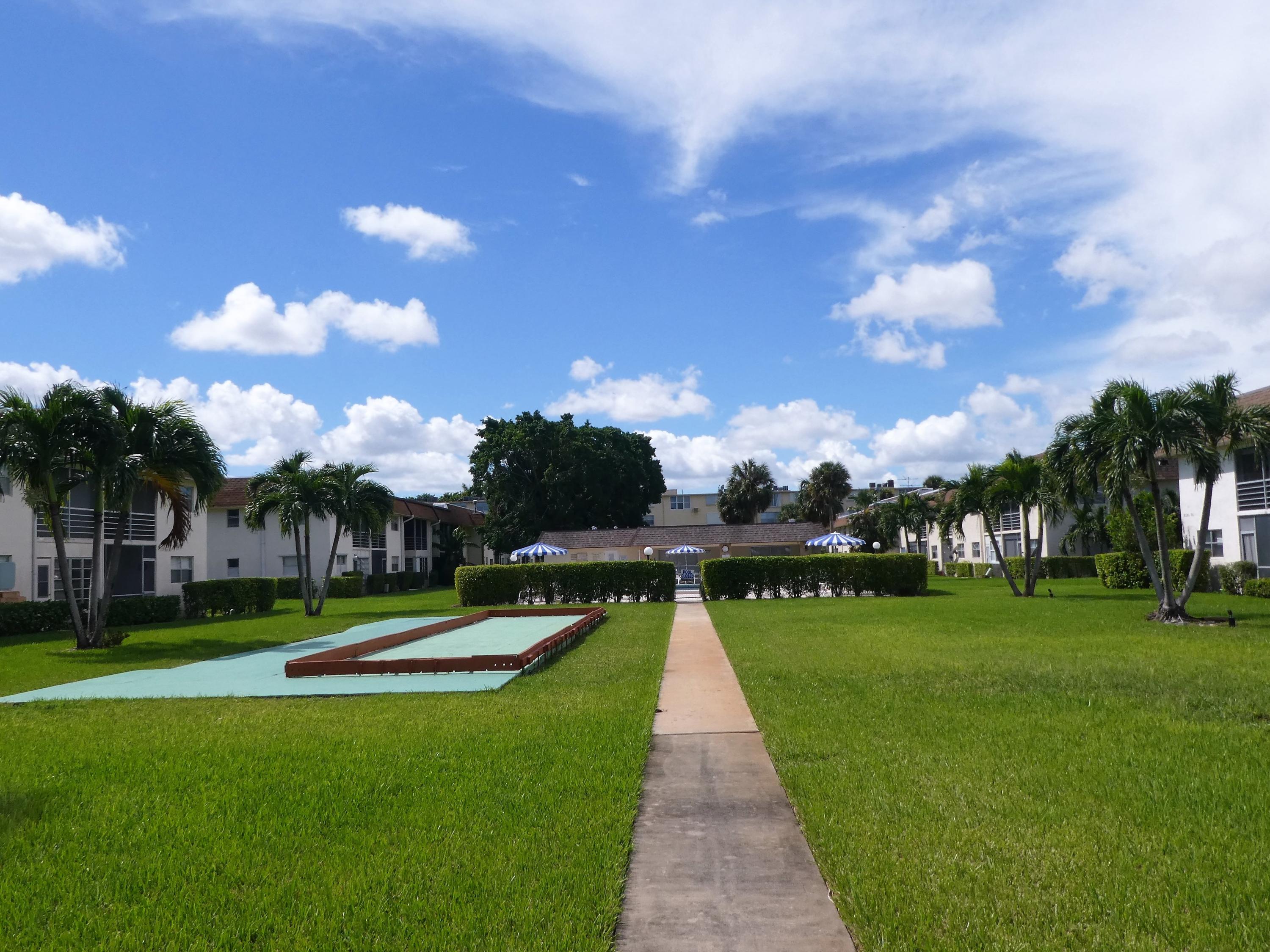 9855 Sandalfoot Boulevard, Unit 306 Boca Raton, FL 33428 - Photo 14 of 25 a view of a park with swimming pool and trees