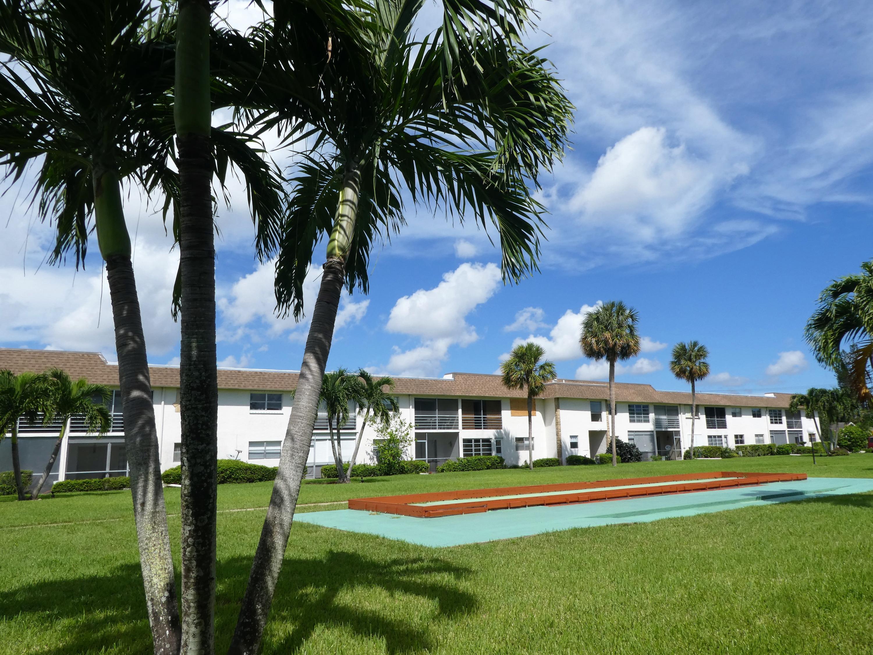 9855 Sandalfoot Boulevard, Unit 306 Boca Raton, FL 33428 - Photo 18 of 25 a front view of a house with swimming pool having outdoor seating