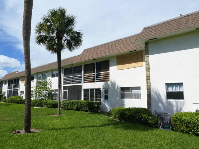 a front view of a house with a garden and yard