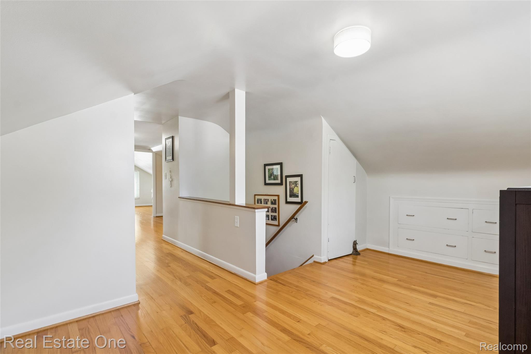 2189 Devonshire Road Bloomfield Hills, MI 48302 - Photo 25 of 50 Hardwood flooring throughout a spacious upper-level area featuring a built-in storage unit with white drawers and a flush-mount ceiling light fixture