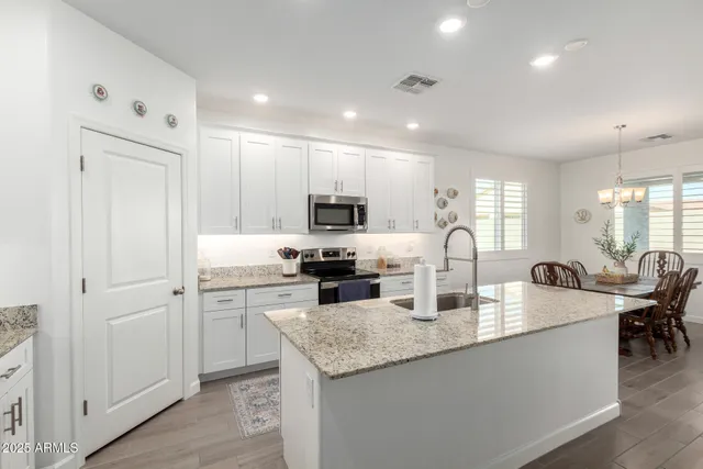 a large kitchen with kitchen island a large counter space a sink a window and stainless steel appliances