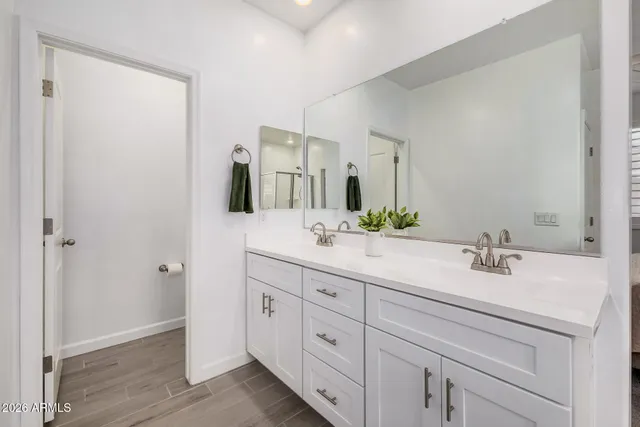 a bathroom with a double vanity sink a mirror and a bathtub