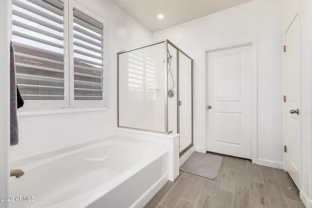 a bathroom with a bathtub a window and a shower
