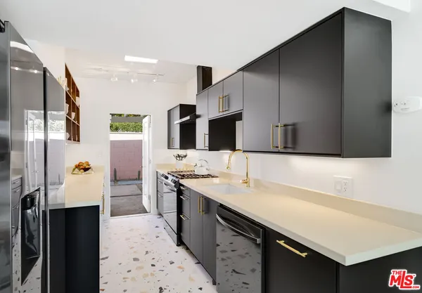 a kitchen with stainless steel appliances a sink stove and cabinets