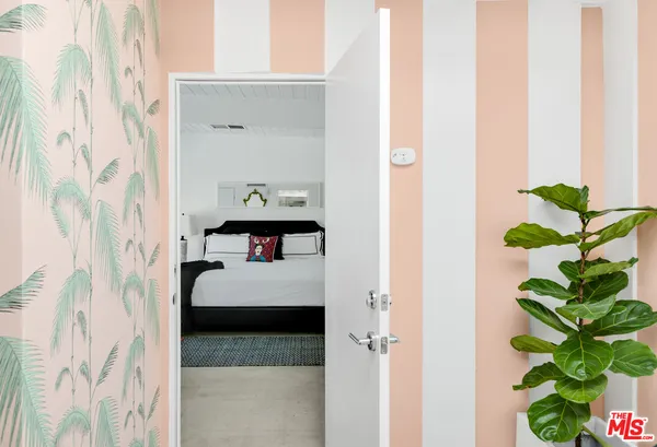 a bedroom with a bed and large windows