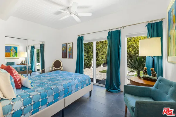 a bedroom with a bed and a lamp on dresser