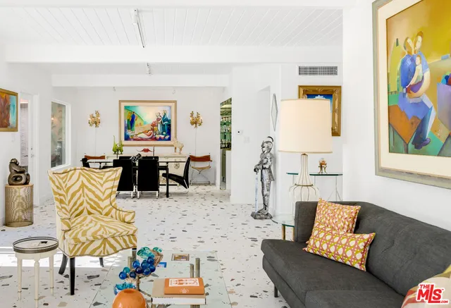 a living room with furniture and painting on the wall