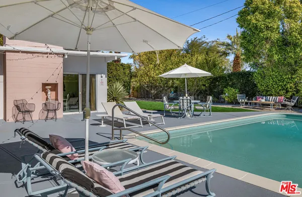 a view of a chair and table in backyard of the house