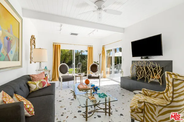 a living room with furniture and painting on the wall